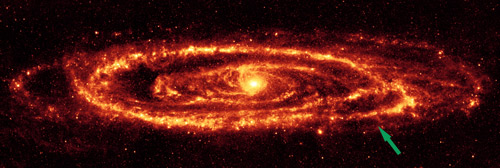 ดาราจักรแอนดรอเมดาในย่านความถี่อินฟราเรด  แสดงวงแหวนสว่างและรูโหว่ (ศรชี้) ที่คาดว่าเกิดจากการพุ่งชนของดาราจักรเอ็ม 32 (ภาพจาก NASA/JPL-Caltech/K. Gordon)