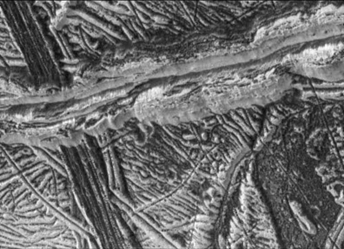 แถบสีดำในภาพเป็นมีความกว้าง 20 กิโลเมตร เป็นทางน้ำแข็งที่เกิดจากน้ำที่อยู่ลึกลงไป ซึ่งเชื่อว่าอาจจะเป็นมหาสมุทรที่มีน้ำอยู่ในรูปของของเหลวใต้พื้นดิน ภาพจาก JPL