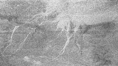 ภาพพื้นผิวไททัน ถ่ายโดยเรดาร์ยานแคสซีนีเมื่อวันที่ 15 กุมภาพันธ์ 2548 แสดงร่องรอยคล้ายสายน้ำไหลมาจากเนินของเซอร์คัสแมกซิมัสซึ่งเป็นหลุมอุกกบาตขนาดใหญ่บนไททัน
